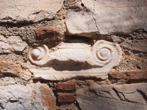 Pagan temple pillar capital embedded in the wall of St. Peter's Church, Kalyvia Thorikou, Greece.